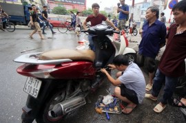 Thợ sửa xe máy hốt bạc sau cơn mưa tại Hà Nội